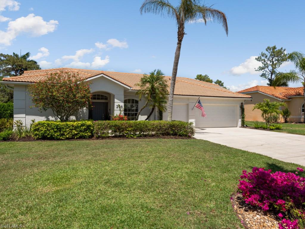 206 Palmetto Dunes Circle Naples, FL 34113 - Photo 2 of 34 a front view of a house with garden