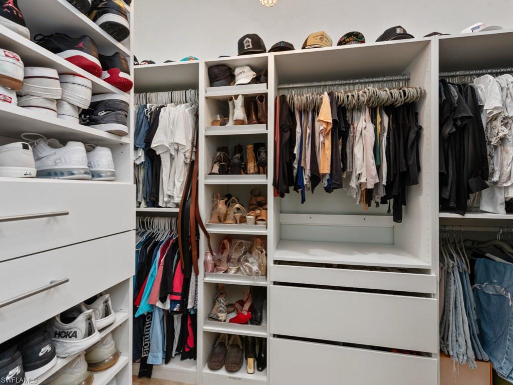 206 Palmetto Dunes Circle Naples, FL 34113 - Photo 19 of 34 a view of walk in closet with clothes and shoes