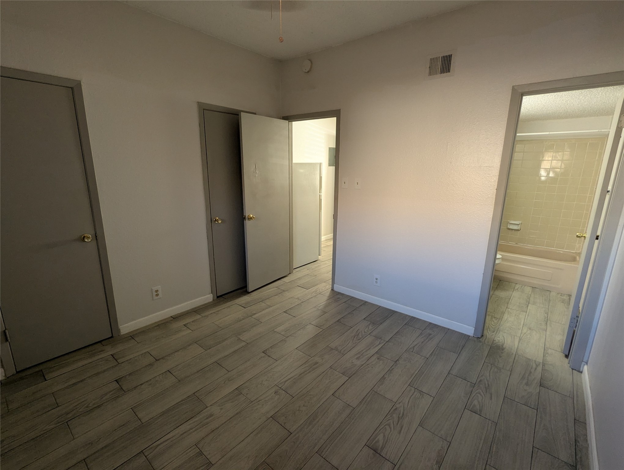 3000 Guadalupe Street, Unit 112 Austin, TX 78705 - Photo 1 of 9 an empty room with wooden floor and a mirror