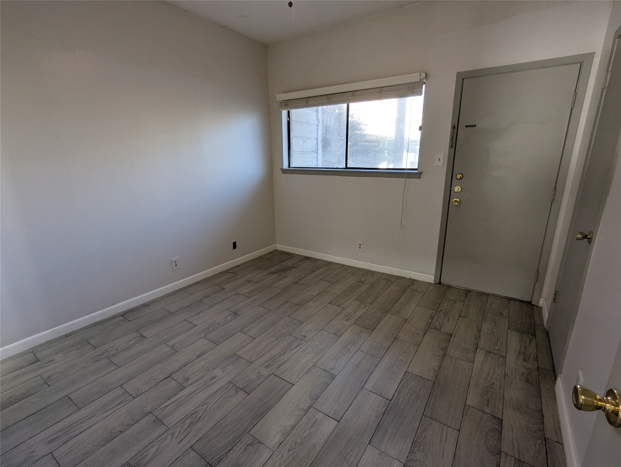 3000 Guadalupe Street, Unit 112 Austin, TX 78705 - Photo 4 of 9 an empty room with wooden floor and windows