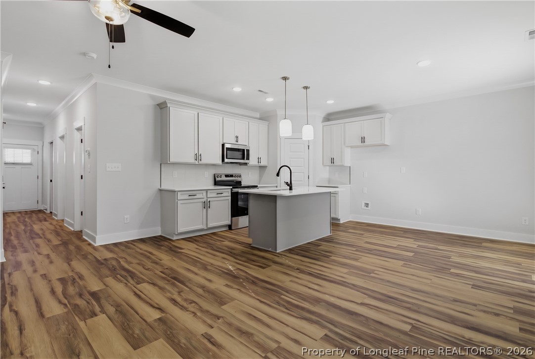 3931 Hamilton Street Hope Mills, NC 28348 - Photo 16 of 50 a large white kitchen with kitchen island a sink stainless steel appliances and cabinets