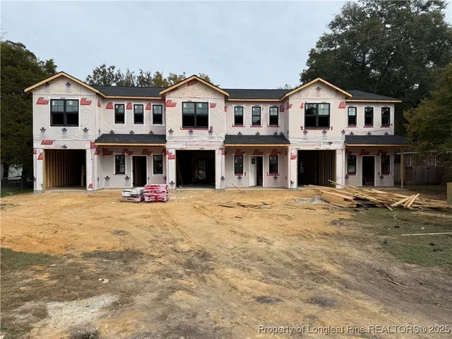a view of a white house with large windows and a yard