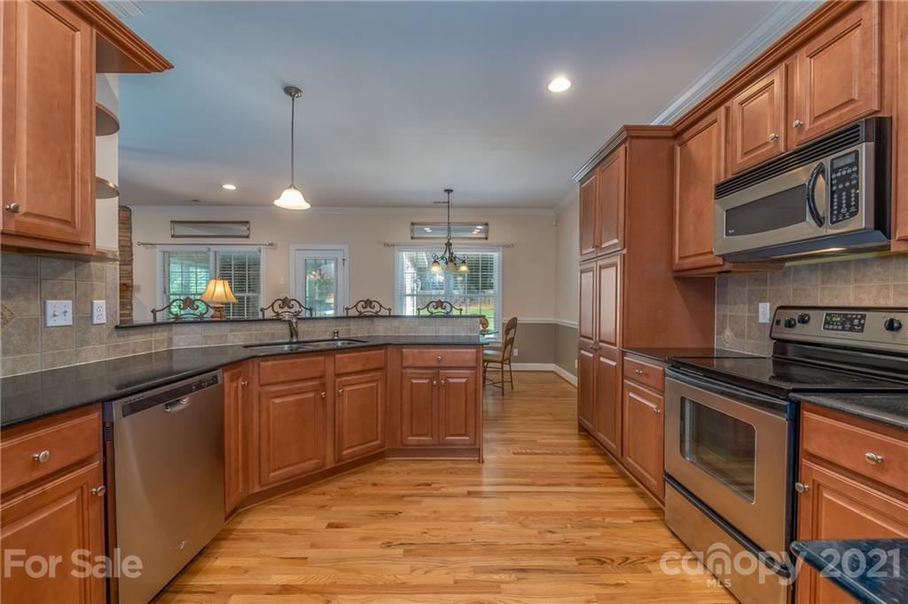 456 Cobblestone Drive Inman, SC 29349 - Photo 11 of 36 a kitchen with stainless steel appliances granite countertop wooden cabinets a stove top oven a sink and dishwasher