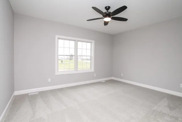 an empty room with a window and a fan