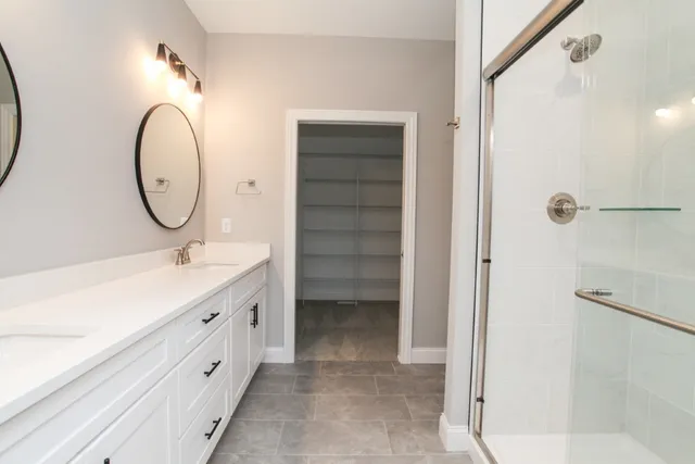 a bathroom with a double vanity sink mirror and a shower