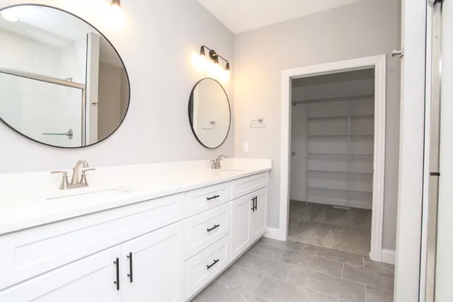 a bathroom with a double vanity sink and a mirror