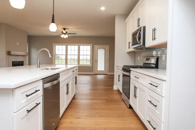 a large kitchen with stainless steel appliances granite countertop a lot of counter space and wooden floors