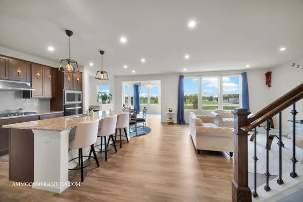 a large white kitchen with lots of counter space dining table and chairs