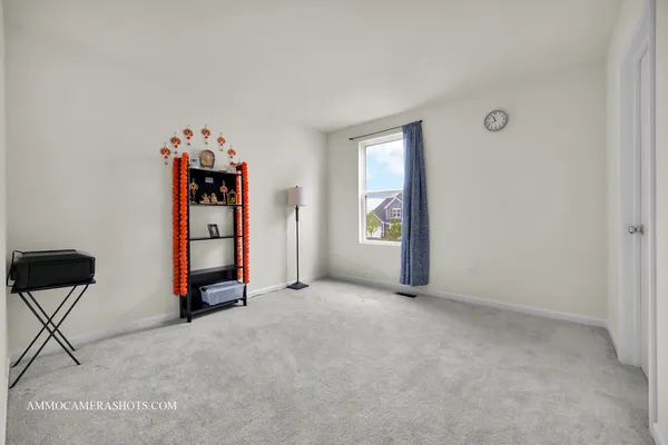 a view of an empty room with closet and a window