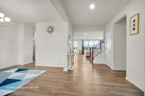 a hallway with wooden floor and a chandelier
