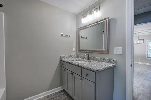 a bathroom with a granite countertop sink and a mirror