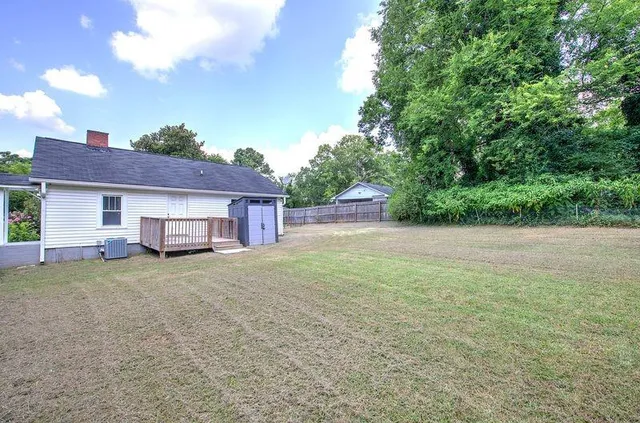 a view of a house with backyard and trees