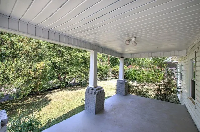 a view of a porch with furniture and garden