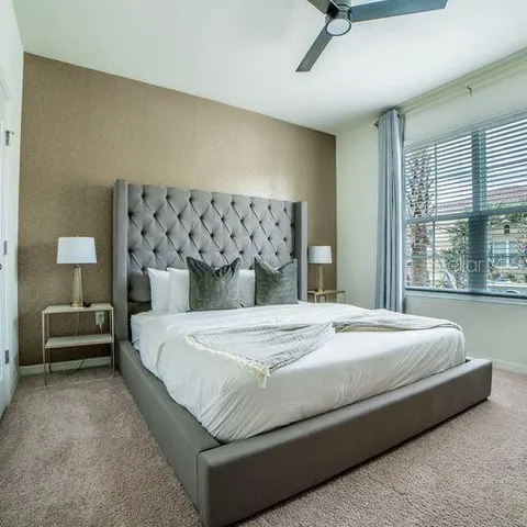 a large bed sitting in a bedroom next to a window