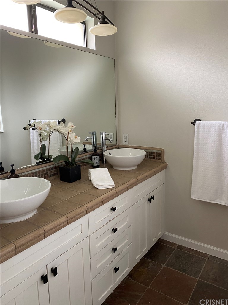 9960 Owensmouth Avenue, Unit 25 Chatsworth, CA 91311 - Photo 12 of 17 a bathroom with a double vanity sink and mirror