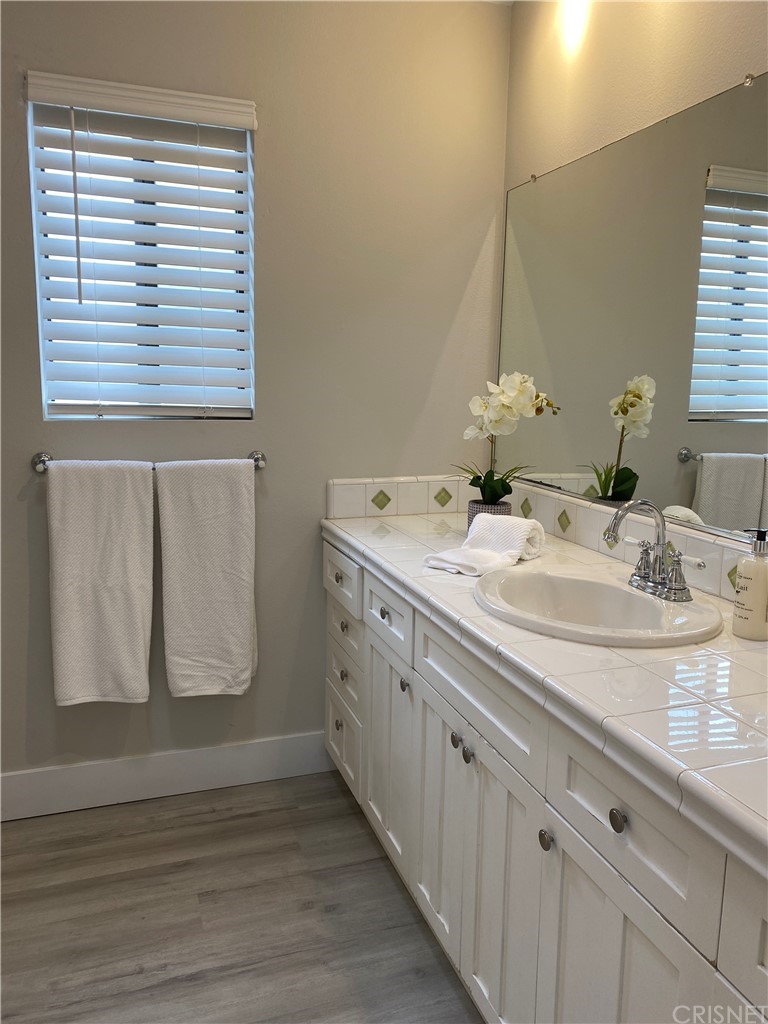 9960 Owensmouth Avenue, Unit 25 Chatsworth, CA 91311 - Photo 14 of 17 a bathroom with a granite countertop sink and a mirror