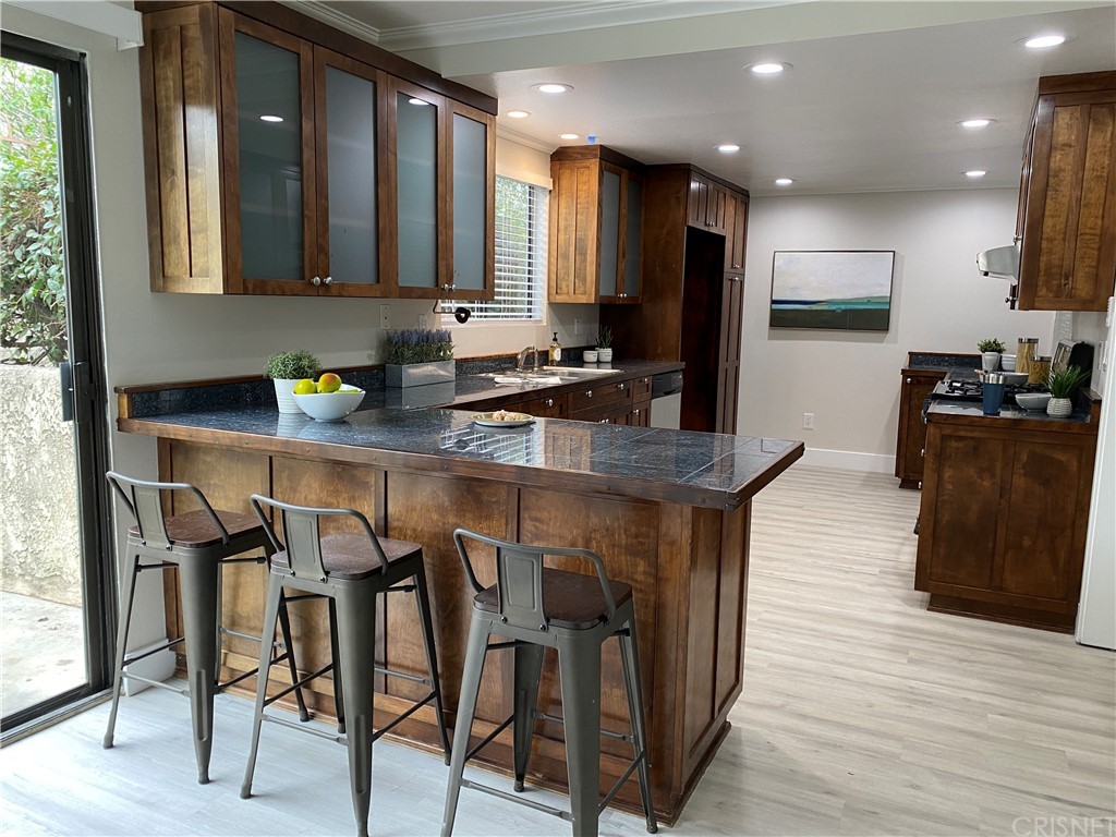 9960 Owensmouth Avenue, Unit 25 Chatsworth, CA 91311 - Photo 6 of 17 a kitchen with cabinets wooden floor and stainless steel appliances