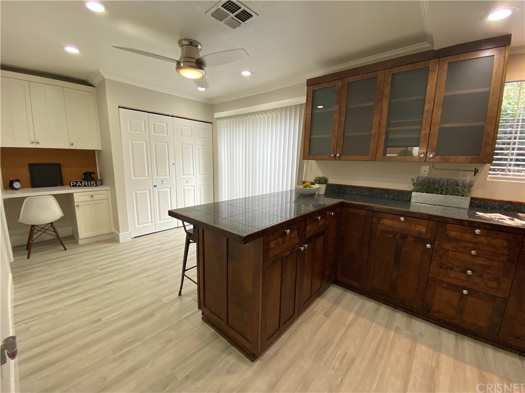 9960 Owensmouth Avenue, Unit 25 Chatsworth, CA 91311 - Photo 7 of 17 a kitchen with a wooden cabinets and outdoor space
