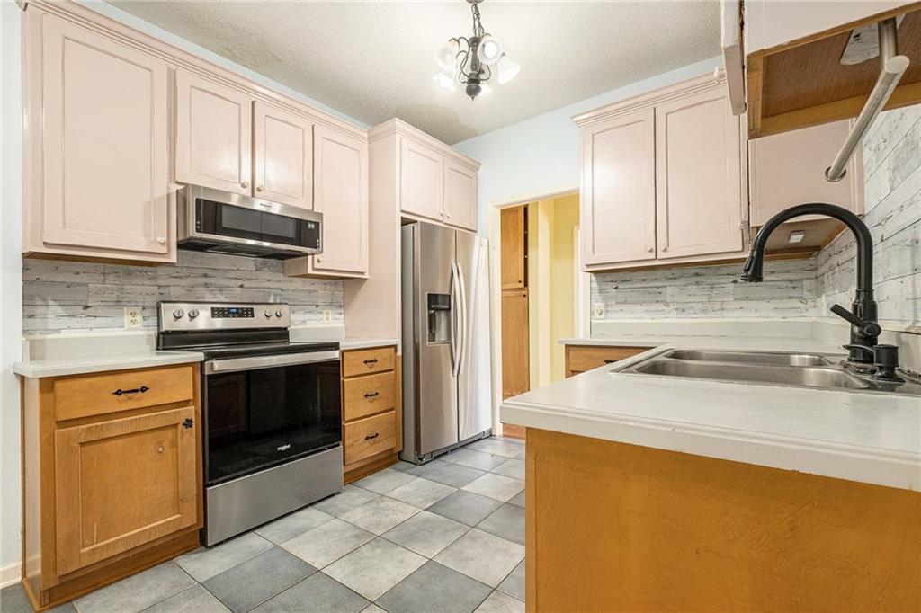 7929 Pea Ridge Road Lula, GA 30554 - Photo 16 of 35 a kitchen with stainless steel appliances granite countertop a stove a sink and a refrigerator