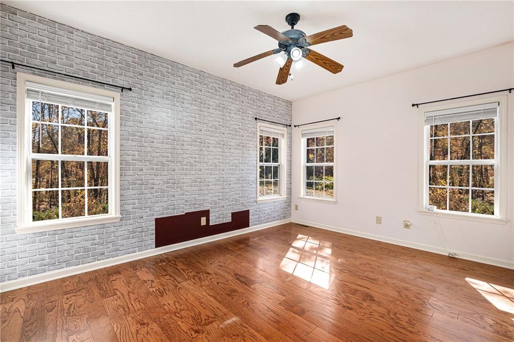 7929 Pea Ridge Road Lula, GA 30554 - Photo 18 of 35 a view of an empty room with a window and wooden floor