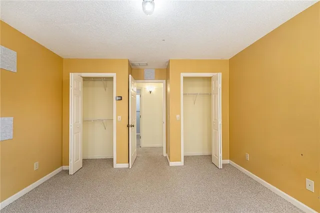 a view of an empty room with closet and a window