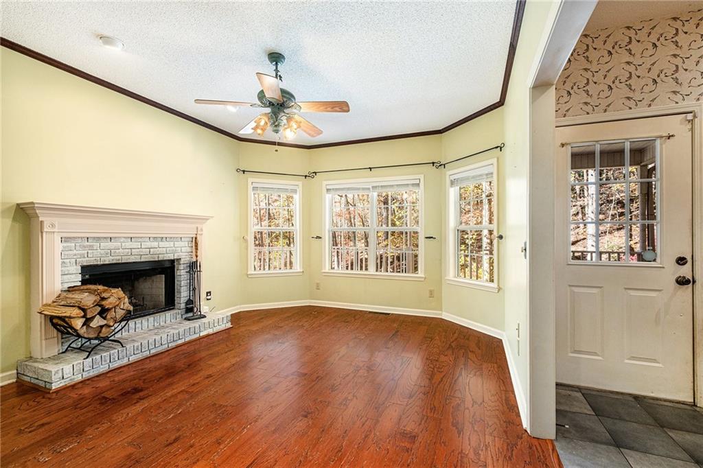 7929 Pea Ridge Road Lula, GA 30554 - Photo 8 of 35 a view of an empty room with wooden floor fireplace and a window