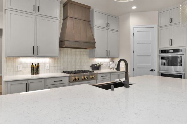 a kitchen with stainless steel appliances a stove refrigerator sink and cabinets