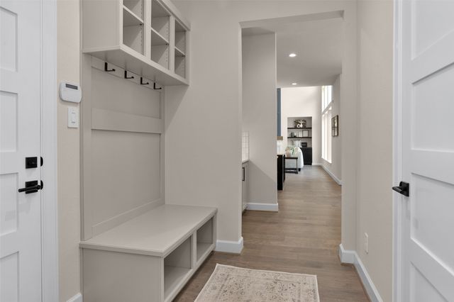 a view of a hallway with wooden floor and staircase