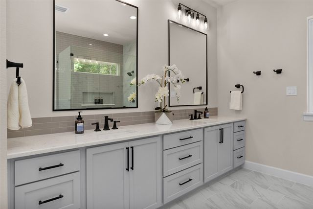 a bathroom with double vanity sink and a mirror