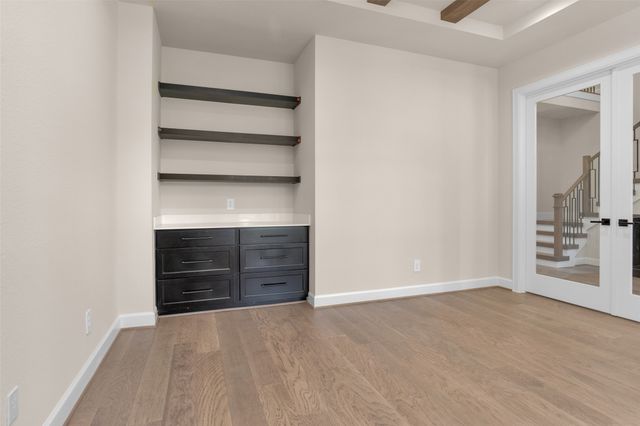 a view of an empty room with cabinet and a bathroom
