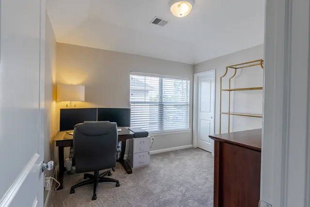 a view of a workspace with furniture and a window