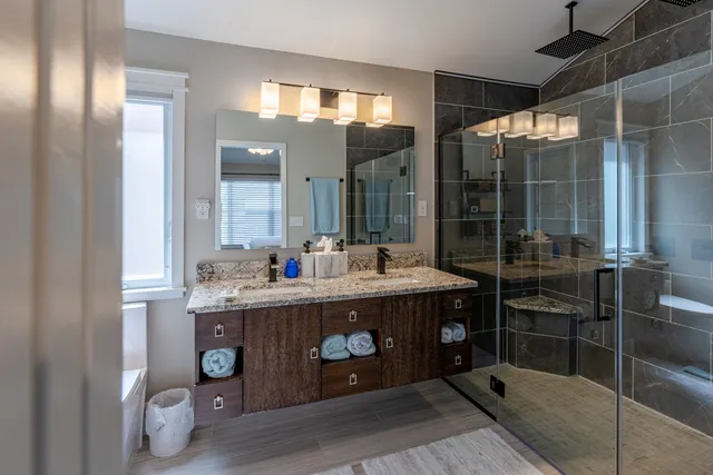 a bathroom with a sink mirror and shower
