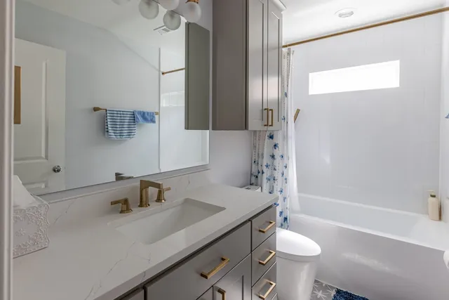 a bathroom with a sink toilet a mirror and shower