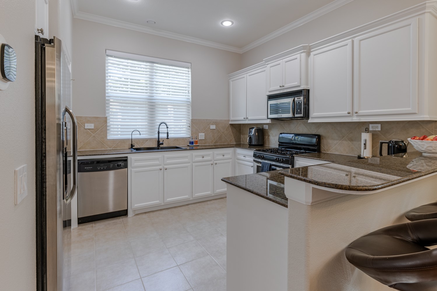 5208 Petty Street, Unit D Houston, TX 77007 - Photo 7 of 39 a kitchen with stainless steel appliances granite countertop a sink stove a refrigerator and white cabinets