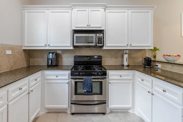a kitchen with white cabinets and white appliances
