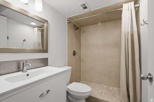1252 Skyline Road Saratoga Springs, UT 84045 - Photo 38 of 51 Bathroom featuring a vanity with an integrated sink, brushed metal hardware, and a subway tile backsplash