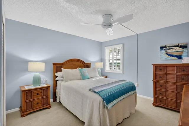 a bedroom with a bed a dresser and a painting