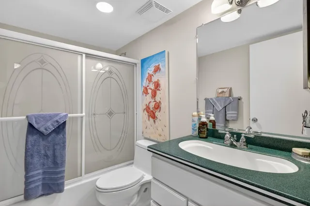 a bathroom with a granite countertop sink toilet and shower