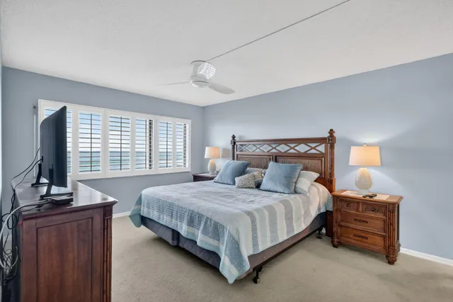 a bedroom with a large bed and a flat tv screen on a dresser