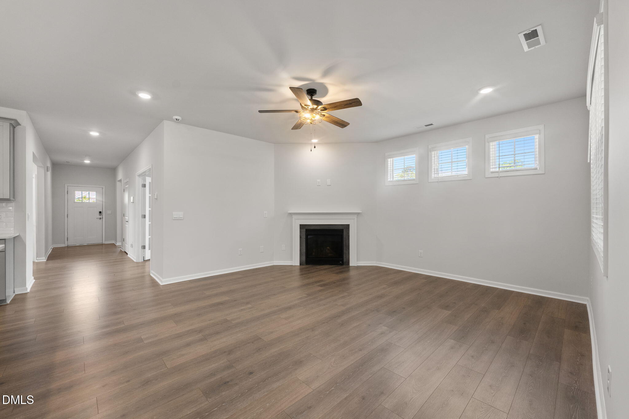 1639 Abberly Place Graham, NC 27253 - Photo 7 of 43 an empty room with wooden floor and a ceiling fan