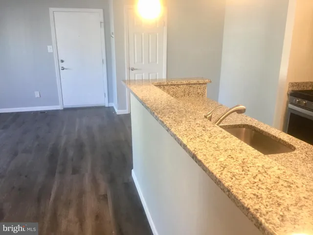 a bathroom with a granite countertop sink and washing machine