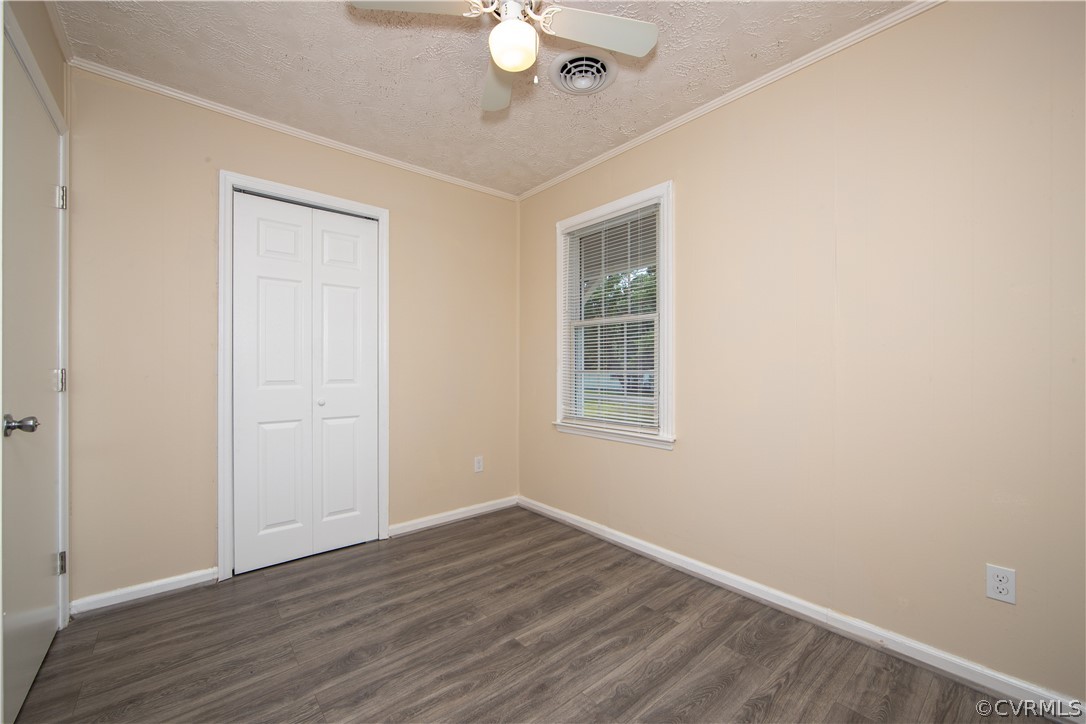 12207 Baltimore Road Ford, VA 23850 - Photo 15 of 24 an empty room with wooden floor chandelier fan and windows