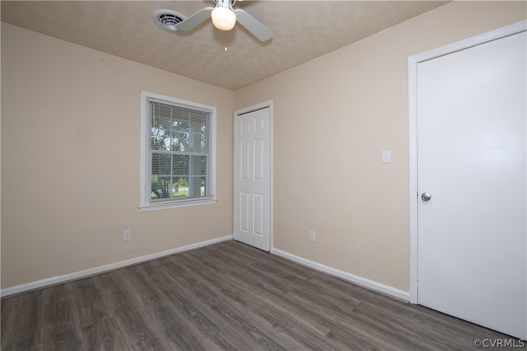 12207 Baltimore Road Ford, VA 23850 - Photo 17 of 24 an empty room with wooden floor fan and windows