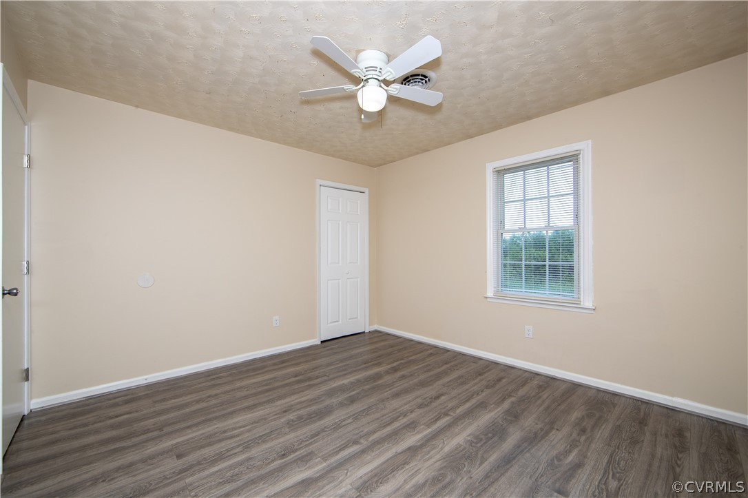12207 Baltimore Road Ford, VA 23850 - Photo 21 of 24 an empty room with wooden floor and ceiling fan