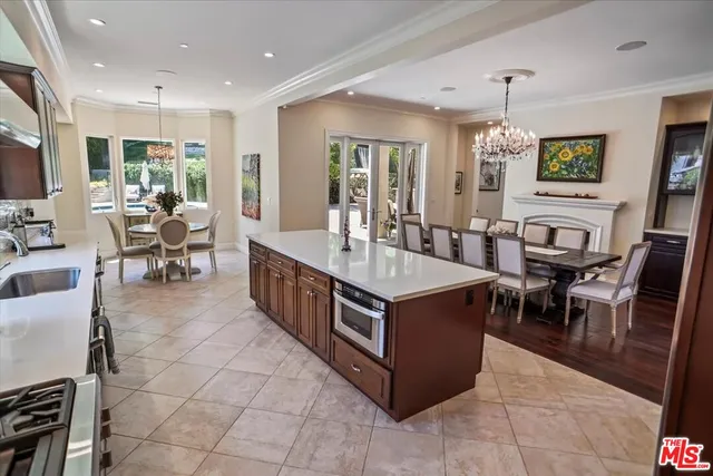 a large kitchen with stainless steel appliances a stove a sink a dining table and chairs