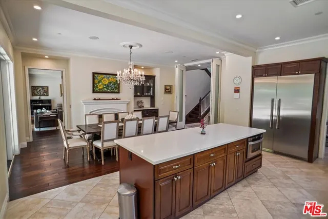 a large kitchen with kitchen island a island a sink a stove and chairs