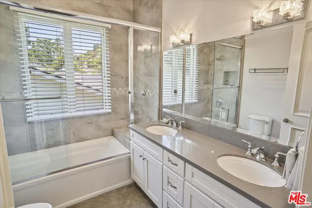 a bathroom with a granite countertop sink and a bathtub