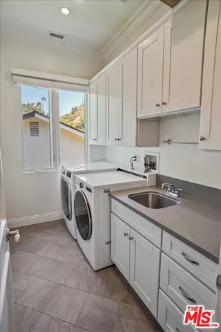 a utility room with sink dryer and washer