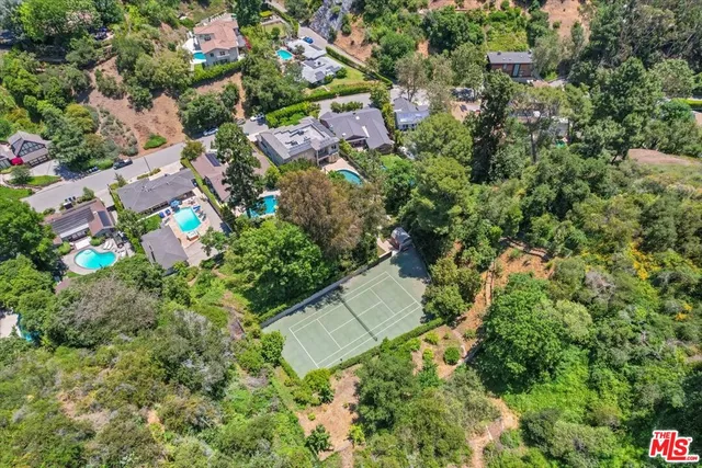 an aerial view of residential house with outdoor space and trees all around