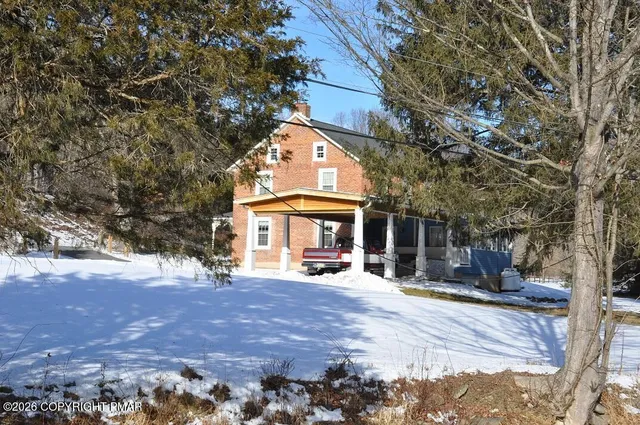 a view of a house with snow on the road